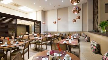 A restaurant with round tables, chairs, and a long bench seating area.