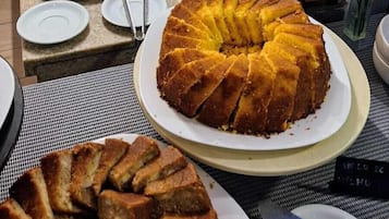 A buffet with various baked goods, including a large bundt cake, arranged on a table.