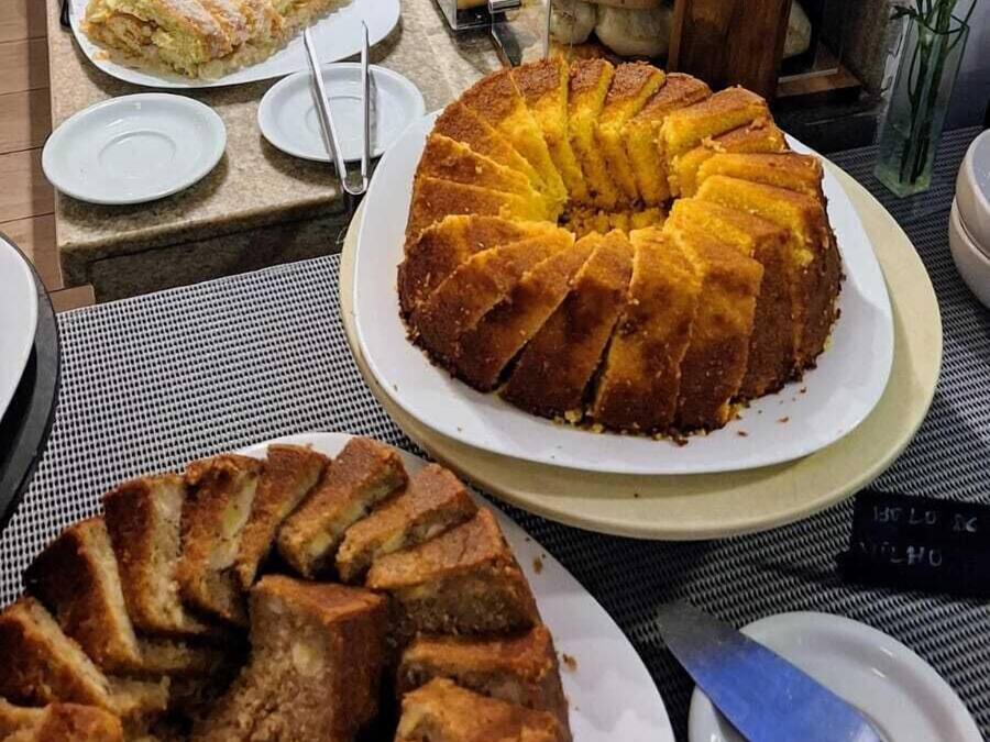 A buffet with various baked goods, including a large bundt cake, arranged on a table.