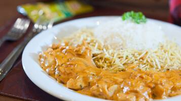 A plate of food with rice and a creamy sauce.