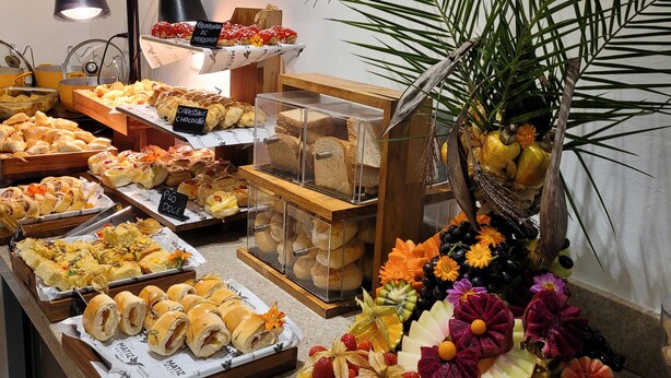 Un bufé con diversas opciones de comida y una presentación de frutas.