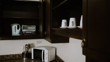 A kitchen with a microwave, toaster, and coffee maker on the countertop.