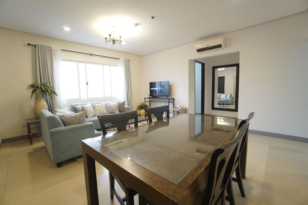 Una sala de estar moderna con un sofá, una mesa de comedor y un televisor.