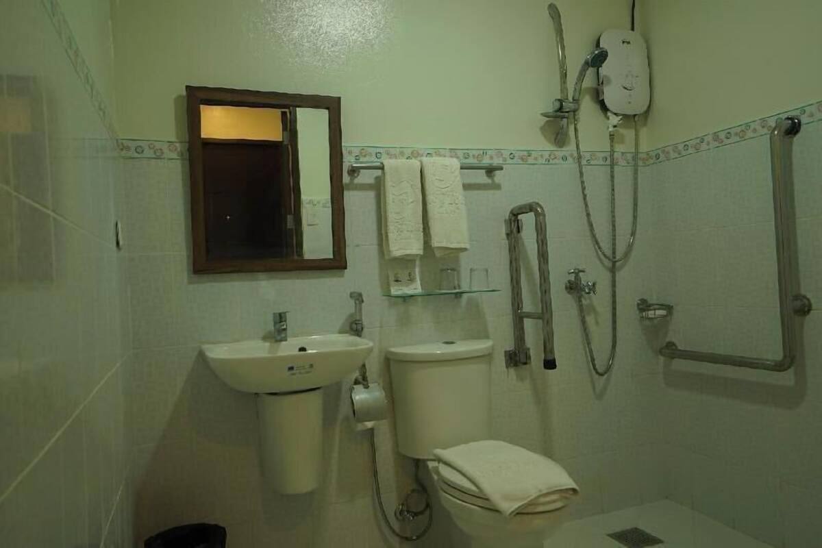Un baño con lavabo, inodoro, ducha y espejo.
