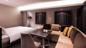 Une chambre d’hôtel avec un lit, un canapé, une table et une chaise.