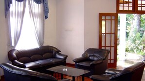 Un salon avec un canapé, deux fauteuils et une table basse.