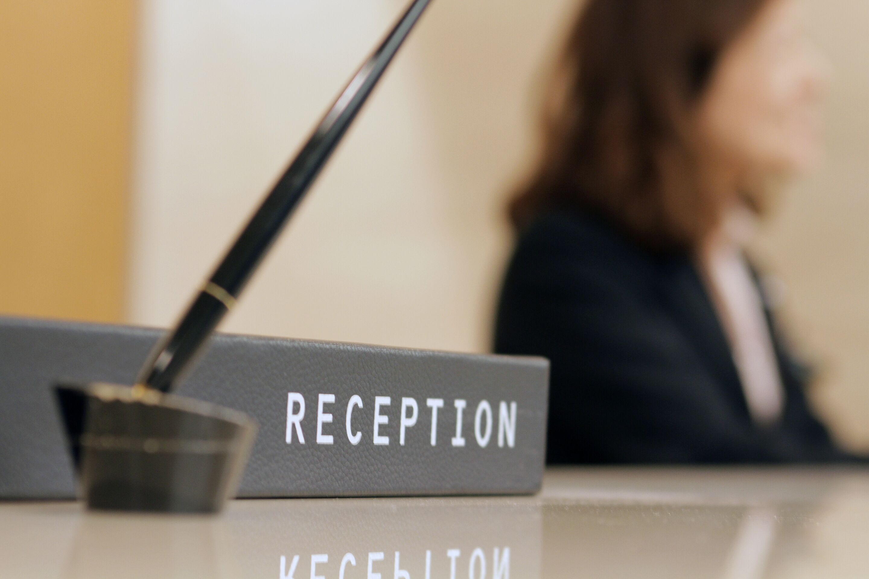 Un mostrador de recepción con un cartel que dice 'RECEPTION' y un micrófono.