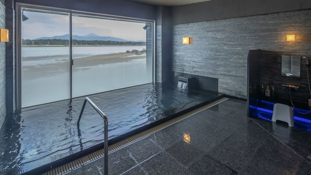 A modern indoor pool with a view of a lake and mountains. - Karatsu Daiichi Hotel Riviere (Karatsu)
