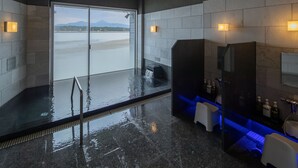 A modern bathroom with a large window, a bathtub, and a sink area. - Karatsu Daiichi Hotel Riviere (Karatsu)
