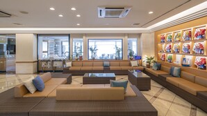 A spacious lobby with a large seating area, a wall display of souvenirs, and large windows providing natural light. - Karatsu Daiichi Hotel Riviere (Karatsu)