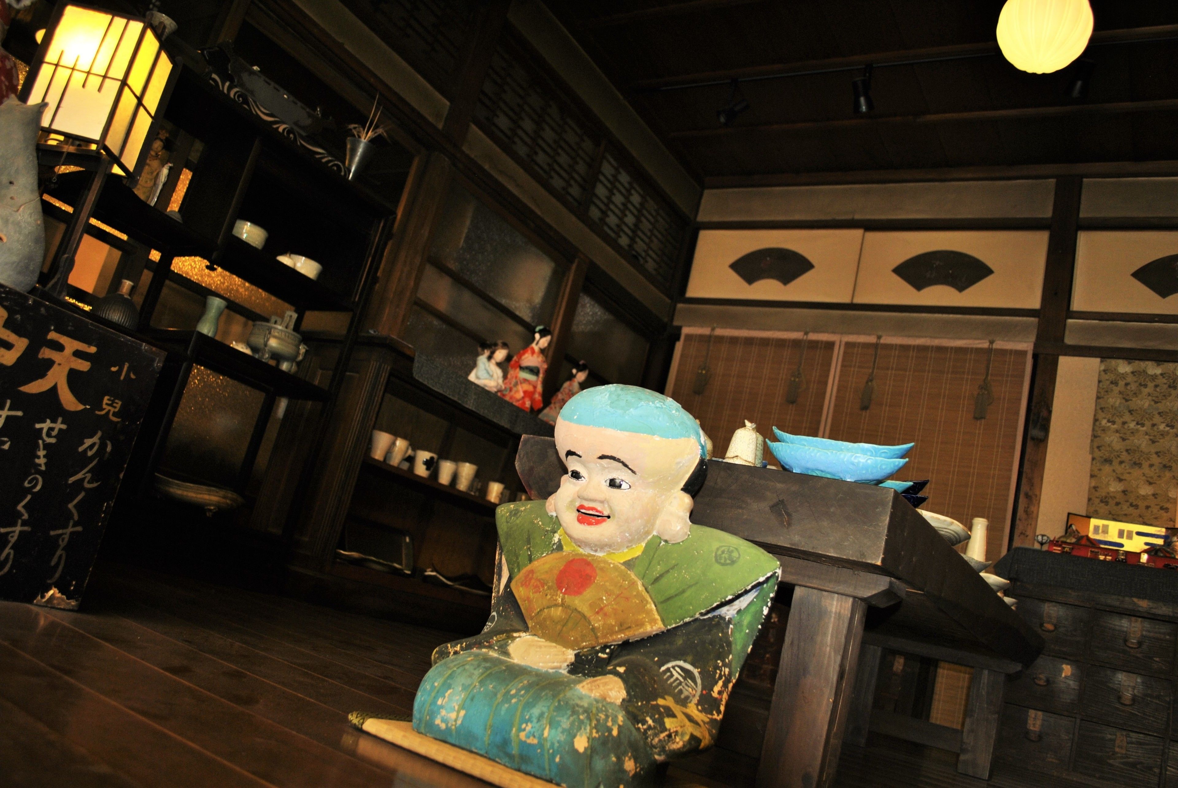 A traditional Japanese room with tatami flooring, a low table, and a decorative alcove with a hanging scroll.