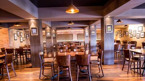 A spacious restaurant with high wooden ceilings, multiple dining tables, and modern pendant lighting. - Gateway Hotel (Port Moresby)