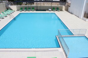 季節性室外游泳池，提供泳池遮陽傘和日光浴躺椅