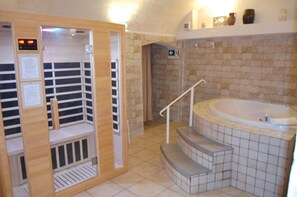 Un sauna avec une porte en bois, un écran numérique et un sol carrelé.
