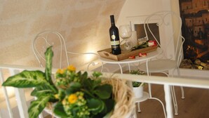 A dining table with a bottle of wine, a glass, and a tray with food items. - Antica Mateola Rooms&Suites (Matera)