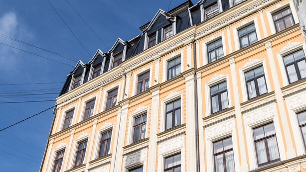 A multi-story building with ornate architectural details, large windows, and a flat roof. - Mosaic Center Apartments (Riga)