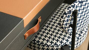 A close-up of a suitcase with a brown handle and a patterned fabric item with a blue and white houndstooth design.