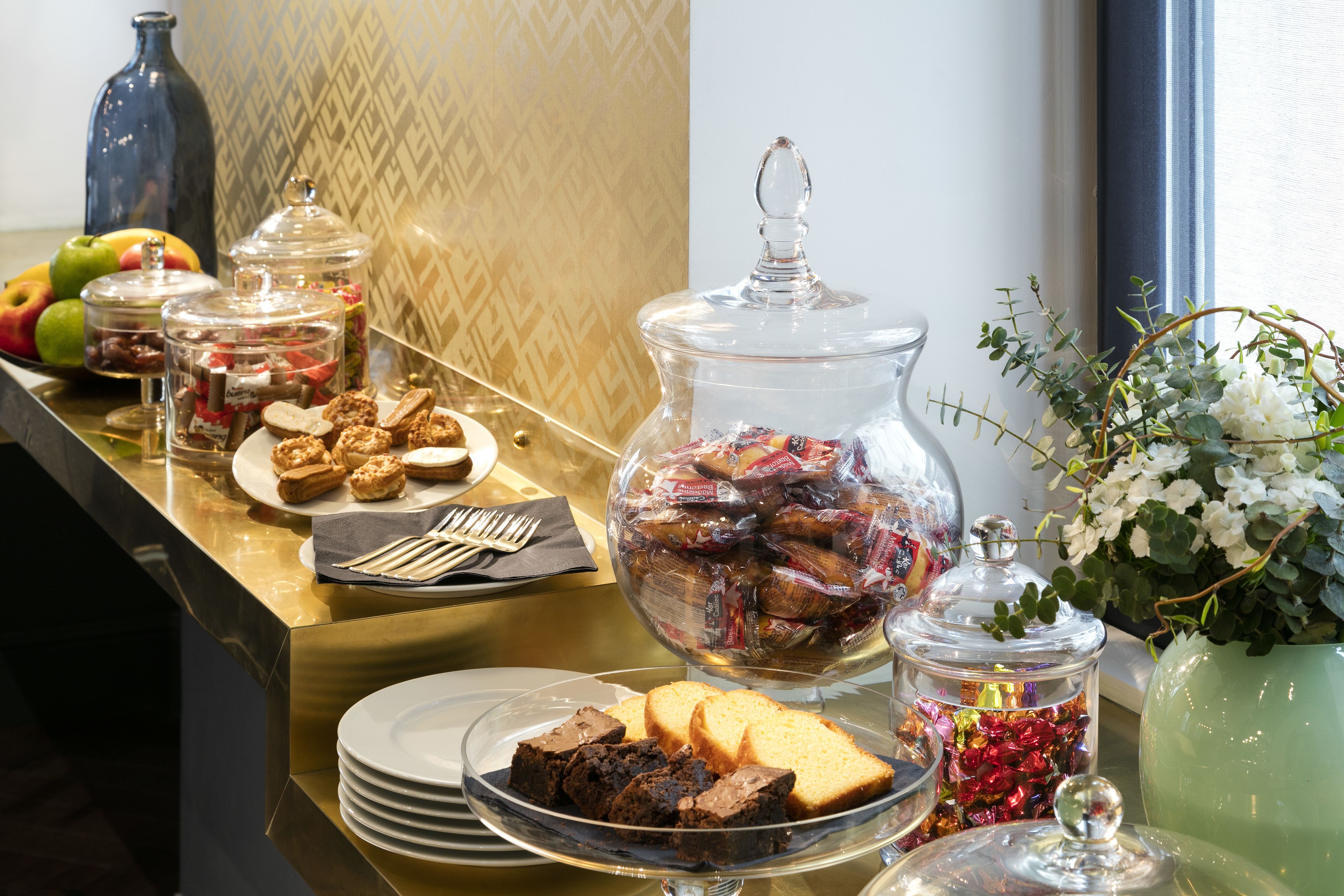 A buffet table with various food items and glass containers.