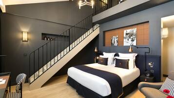 A modern bedroom with a large bed, a staircase, and a view of the city.