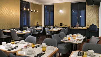 A restaurant with multiple tables, chairs, and a variety of dining ware.