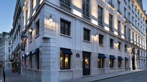 A multi-story building with a classical architectural style, featuring evenly spaced windows and balconies. - Hotel Square Louvois (Paris)