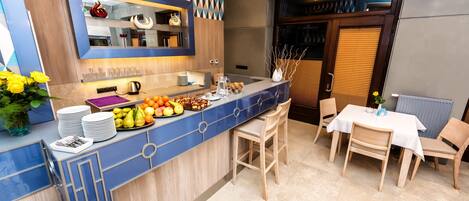 A modern kitchen with a blue countertop, wooden cabinets, and a dining area with a table and chairs.
