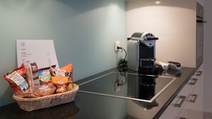 Eine Küche mit Kaffeemaschine, einer Snack-Korb und einer Speisekarte auf der Arbeitsfläche.