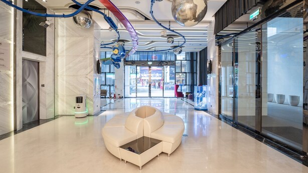 A modern lobby with a central seating area, a glass wall, and a ceiling with unique lighting fixtures. - Guide Hotel Taichung ZiYou (Taichung)