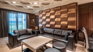 A modern living room with a sectional sofa, a glass coffee table, and a leather armchair. - Guide Hotel Taichung ZiYou (Taichung)