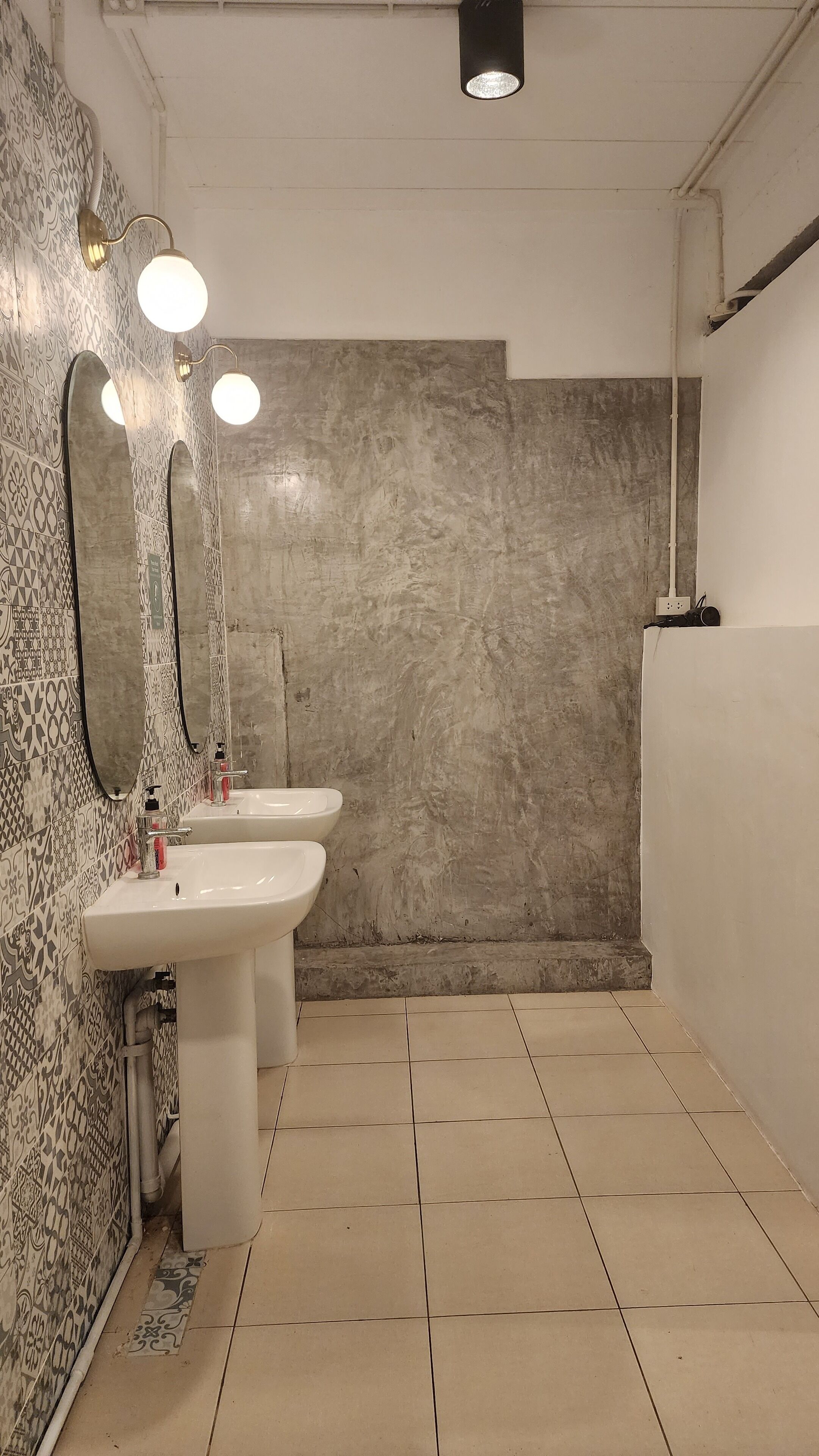 Une salle de bain avec deux lavabos, un grand miroir et un espace douche.
