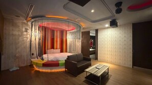Ein modernes Schlafzimmer mit Bett, einer Couch, einem Couchtisch und einer ungewöhnlichen, runden Fensterkuppel.