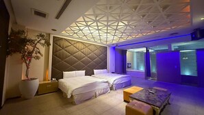 Een moderne hotelkamer met een groot bed, een zithoek en uitzicht op de stad.