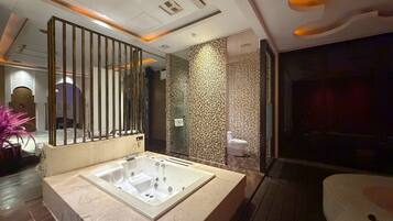 A modern bathroom with a large bathtub, a glass shower enclosure, and a decorative wall panel.