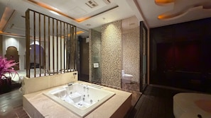A modern bathroom with a large bathtub, a glass shower enclosure, and a decorative wall panel.