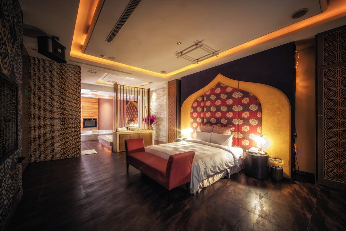 Une chambre d’hôtel moderne, dotée d’un grand lit, d’un bureau et d’une coiffeuse.