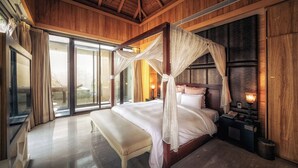 Um quarto espaçoso com uma cama grande, um banquinho e um dossel.