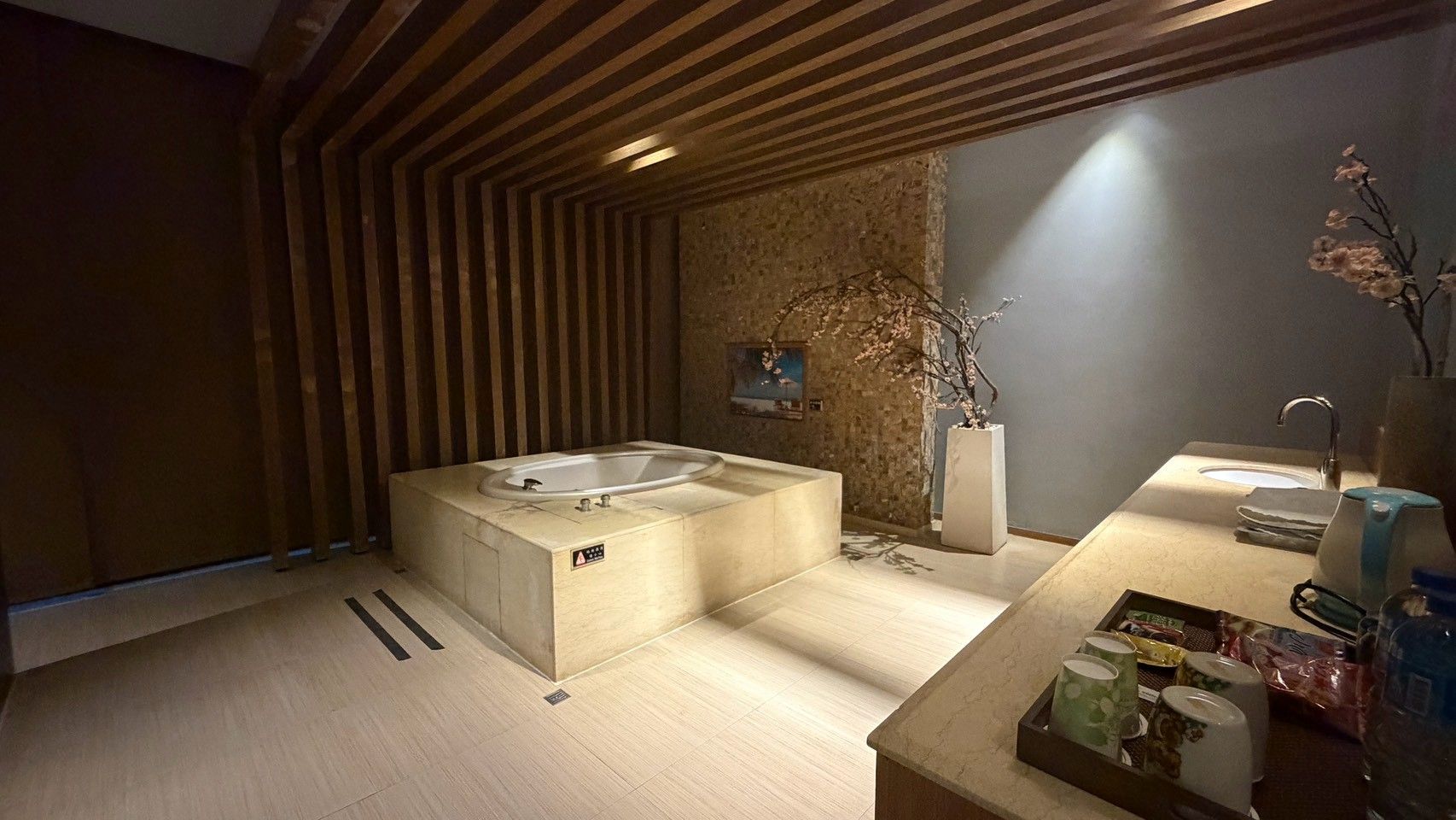 Un baño moderno con una bañera independiente, un lavamanos y un tocador con artículos de aseo.
