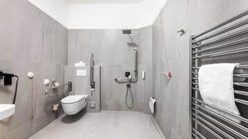 A modern bathroom with a toilet, bidet, and shower.