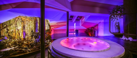 A spa area with a hot tub, a rock garden, and a seating area.