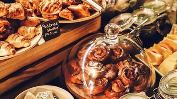 Een buffet met diverse gebakjes, jam en toevoegingen.