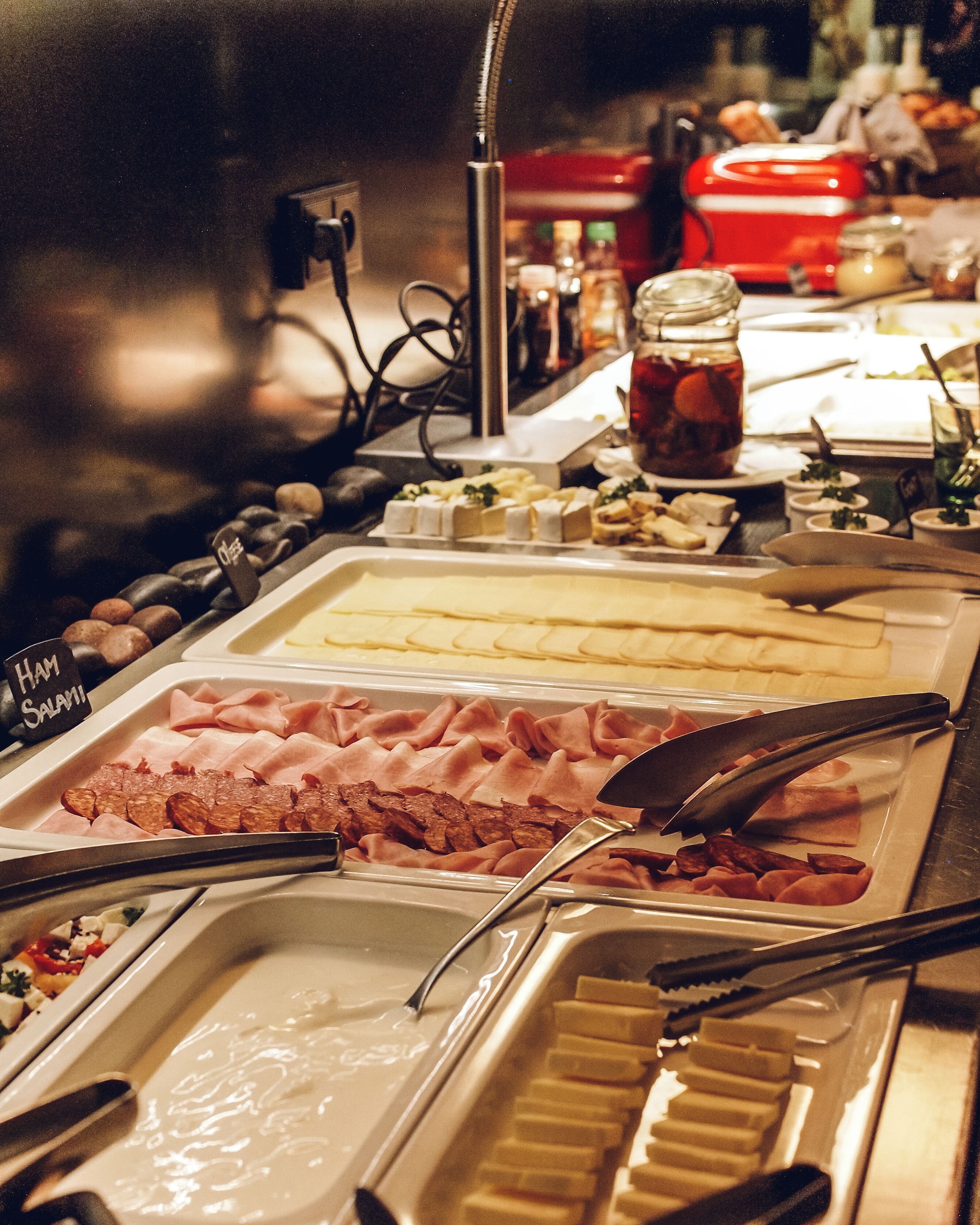 A buffet with various food items including ham, cheese, and other deli selections.