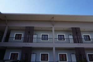 A multi-story building with balconies, windows with curtains, and a flat roof. - Sandee Homeplace (Udon Thani)