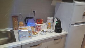 Una encimera de cocina con diversos elementos, incluyendo una caja de biscotti leFresche, una caja de té Star, una tetera, un tostador y un refrigerador.