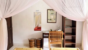 Una habitación con cama, escritorio, silla y dos cestas.