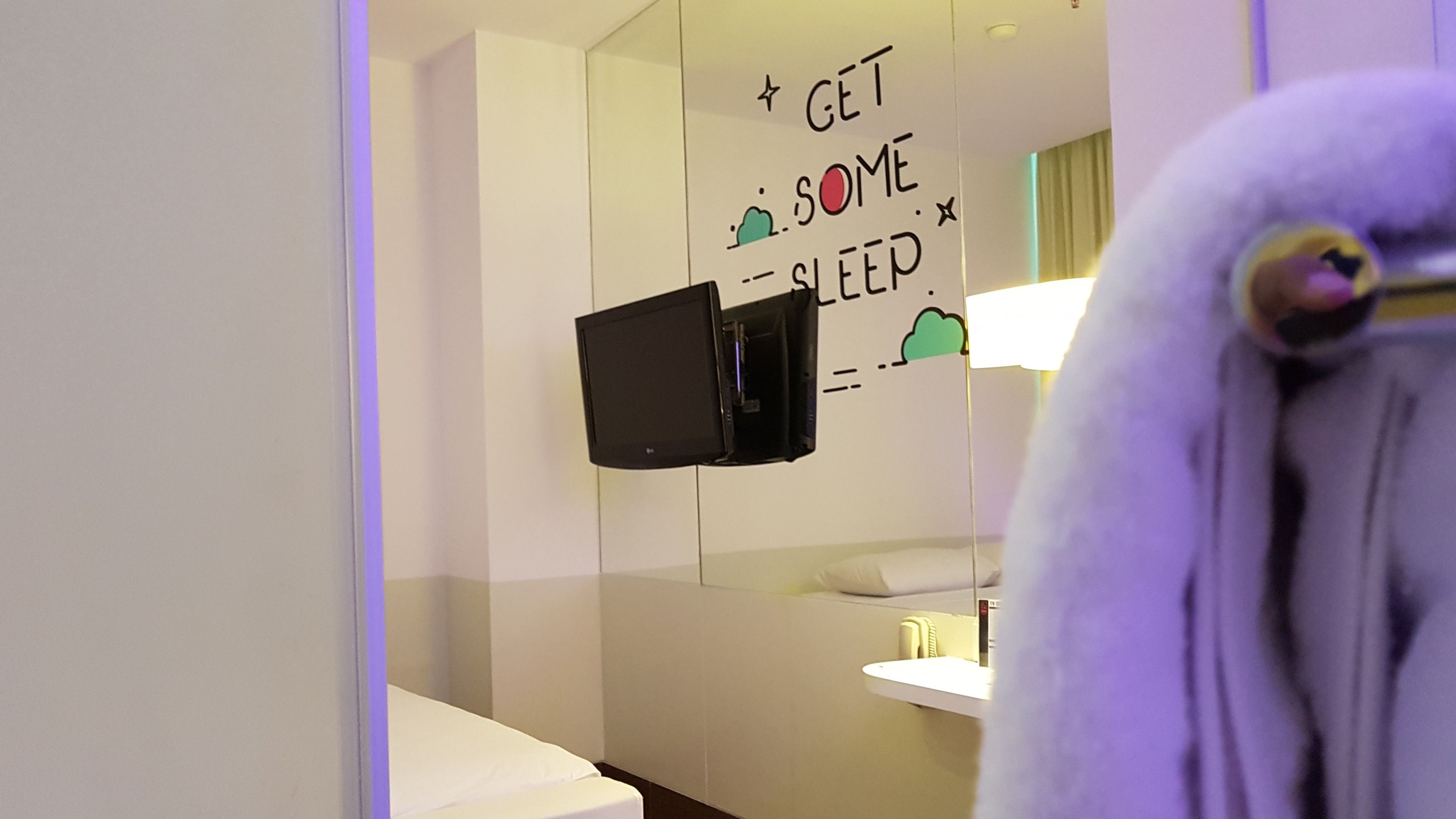 Un baño con un perchero, un espejo y una pared con una cita motivacional.