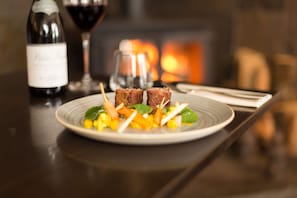 Une assiette de nourriture, une bouteille de vin et un verre de vin, le tout posé sur une table.