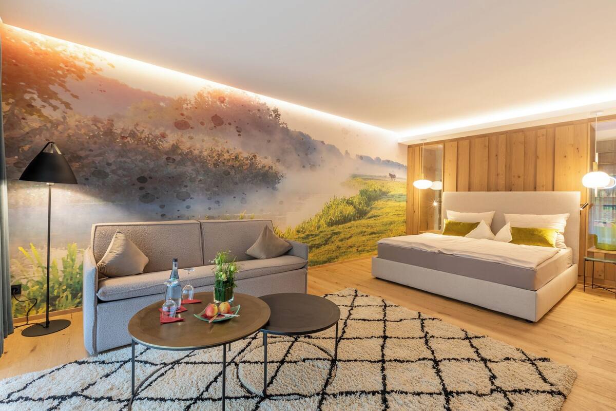Ein modernes Schlafzimmer mit einem großen Bett, einer Couch und einem Couchtisch.