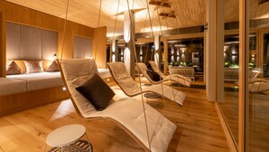 Un área de descanso moderna con piso de madera, sillones cómodos y un rincón de sofás.