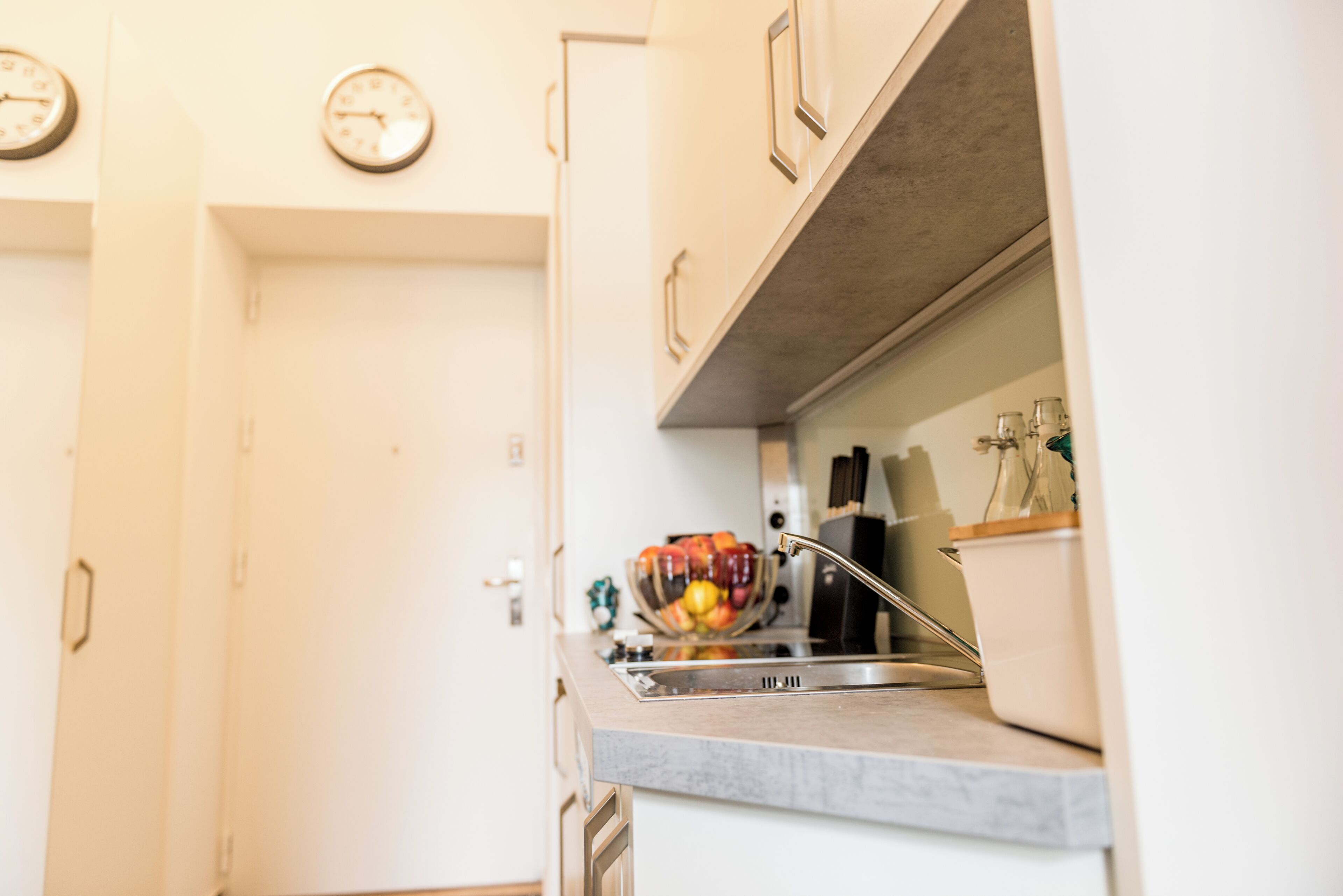 Een keuken met een spoelbak, een fruitschaal en een koffiezetapparaat.