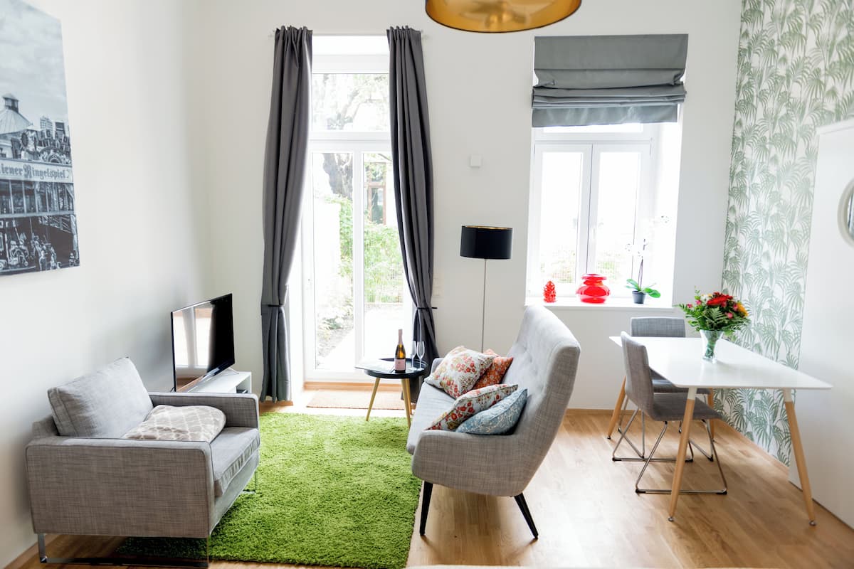 Una sala moderna con sofá, sillón y mesa de comedor.